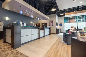 Image of a store interior with a front desk, wooden flooring, and decorative items, showcasing a modern and inviting atmosphere.