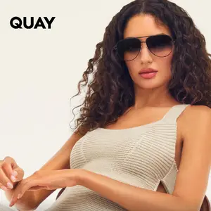 A woman wearing sunglasses with curly hair and a knitted dress