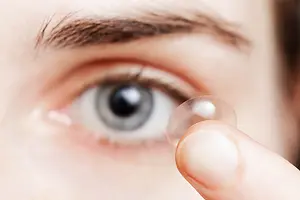 woman wearing contact lens in her eye