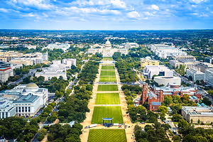 Aerial view of the National Mall in Washington D.C. featuring the Capitol building and multiple large buildings.