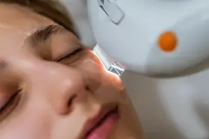 Woman getting a facial treatment using laser equipment