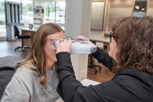 A woman is having her eyes examined by an optometrist in an eye clinic