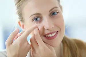 woman wearing a contact lens on her eye