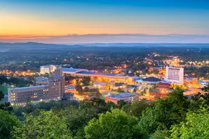 A view of fort smith ar with many buildings and trees from the top of a hill during the sunset