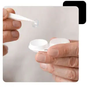 A person inserting a contact lens into a case