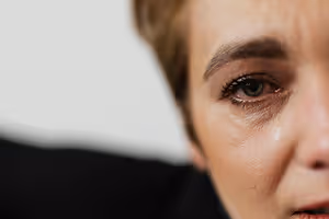 A close-up view of a woman crying with tears running down her face