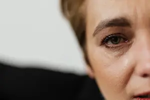 A close-up view of a woman crying with tears running down her face