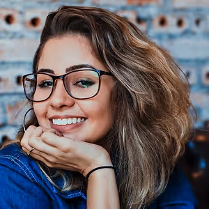 A smiling woman with glasses and long hair posing for a picture
