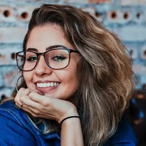 A smiling woman with glasses and long hair posing for a picture