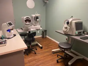 a room with 2 chairs and 2 tables with an ophthalmoscope on top of them