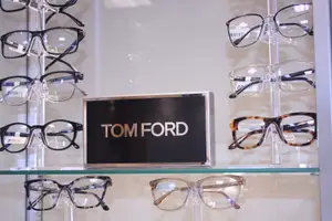 A display of Tom Ford eyeglasses in a store with a sign in front of it