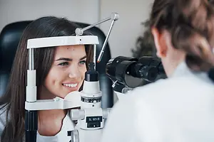A woman is having her eye examined by a doctor in a clinic