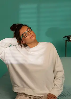 woman with glasses lying on bed