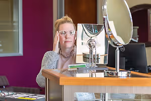 woman wearing glasses in front of a mirror