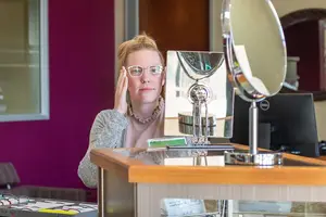 woman wearing glasses in front of a mirror