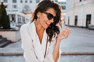 A woman smiling and posing for a photo in a city street with buildings in the background