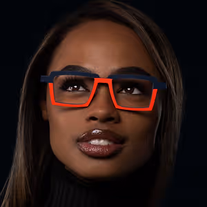A woman wearing glasses with a blue frame and red accents and a black turtleneck
