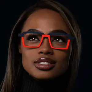A woman wearing glasses with a blue frame and red accents and a black turtleneck