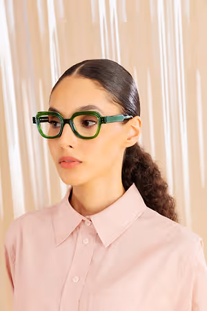 Woman wearing pink shirt and green rectangular glasses