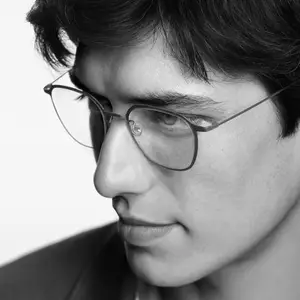 Close up of a man's face with glasses on and a serious expression