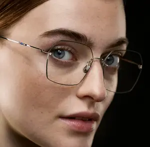 A woman with blue eyes wearing a pair of glasses with a metallic frame
