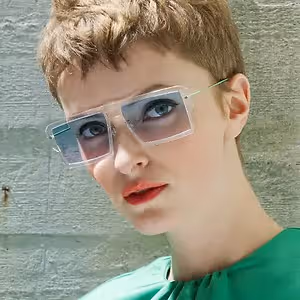 A woman with short hair and wearing sunglasses is posing for a picture