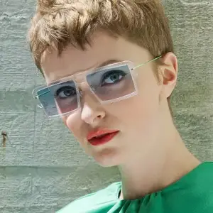A woman with short hair and wearing sunglasses is posing for a picture