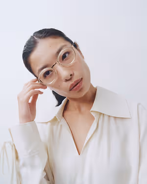 woman wearing glasses and a white blouse posing for a photo