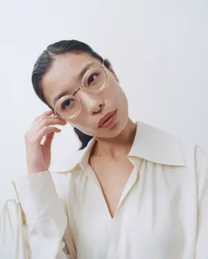 woman wearing glasses and a white blouse posing for a photo