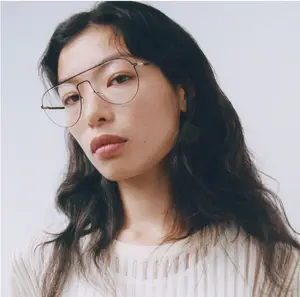 A woman wearing eyeglasses and a white striped shirt posing for a picture