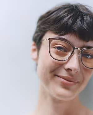 Close up of a smiling woman wearing glasses.