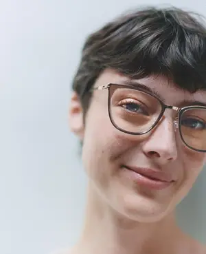 Close up of a smiling woman wearing glasses.