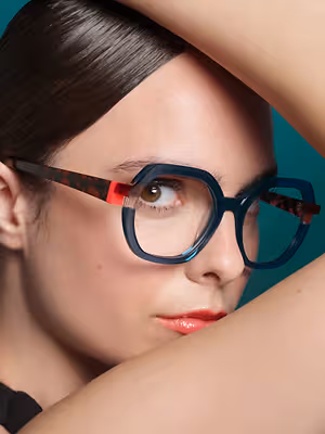 woman wearing blue and red glasses posing for a picture
