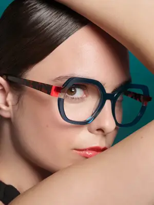woman wearing blue and red glasses posing for a picture