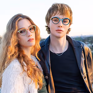 A man and woman with glasses in a rooftop photo