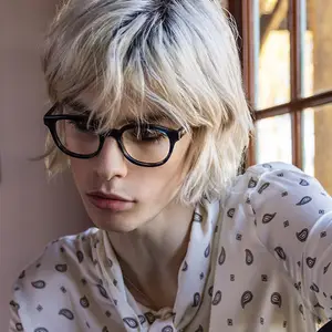 Woman with short blonde hair and glasses looking at something in front of her