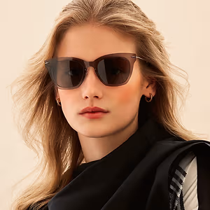 Closeup of a woman wearing sunglasses with brown frames and dark lenses.