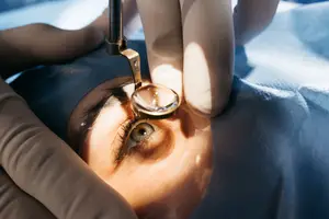 A medical professional is using a magnifying tool to examine a patient's eye.