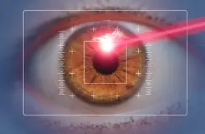 A close-up of an eye with a laser beam shining on the iris