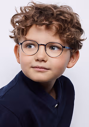 Close-up of a boy with curly hair and blue eyes wearing glasses and a blue polo shirt