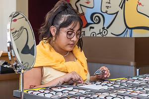 A woman is trying on glasses in a mirror at a store