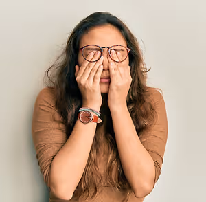 woman rubbing her eyes