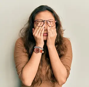 woman rubbing her eyes