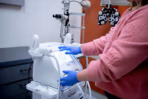 Optometry professional operating an eye examination machine in a clinic