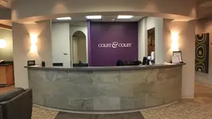 Reception area of a modern office building with a curved stone desk and purple wall, showcasing a welcoming atmosphere
