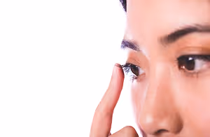 Close up of a woman's face with a finger on her eyelid.