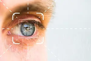 A close-up of a man's eye with a white square on it and a heartbeat line in the corner