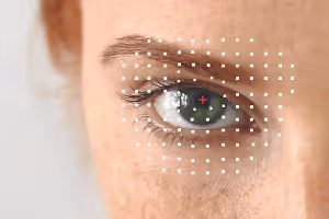 Close up of a woman's eye with a red cross and white dots on her skin