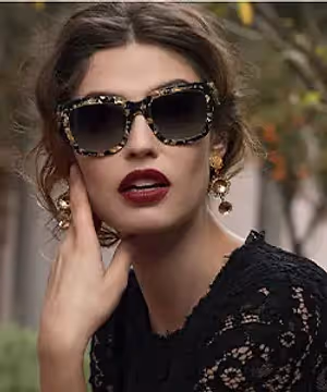 A woman wearing sunglasses and a black lace dress