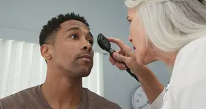 A doctor checking the eyes of a patient with a stethoscope